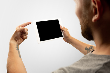 Image showing Close up male hands holding tablet with blank screen during online watching of popular sport matches and championships all around the world. Copyspace for ad