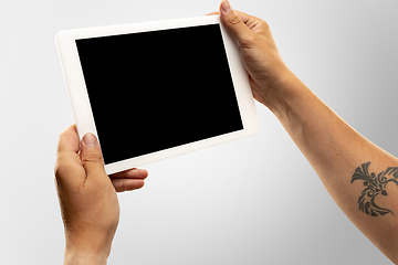 Image showing Close up male hands holding tablet with blank screen during online watching of popular sport matches and championships all around the world. Copyspace for ad