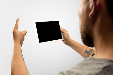 Image showing Close up male hands holding tablet with blank screen during online watching of popular sport matches and championships all around the world. Copyspace for ad