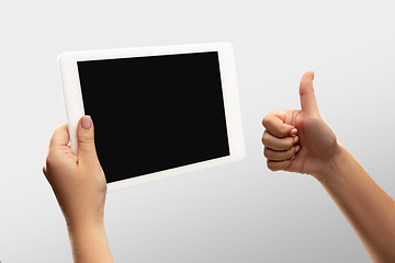 Image showing Close up female hands holding tablet with blank screen during online watching of popular sport matches and championships all around the world. Copyspace for ad