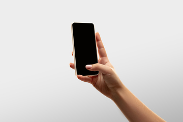 Image showing Close up female hands holding smartphone with blank screen during online watching of popular sport matches and championships all around the world. Copyspace for ad