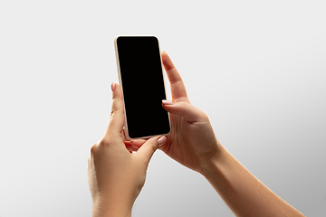 Image showing Close up female hands holding smartphone with blank screen during online watching of popular sport matches and championships all around the world. Copyspace for ad