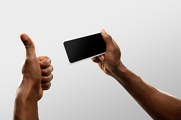 Image showing Close up male hands holding smartphone with blank screen during online watching of popular sport matches and championships all around the world. Copyspace for ad