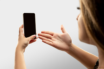 Image showing Close up female hands holding smartphone with blank screen during online watching of popular sport matches and championships all around the world. Copyspace for ad