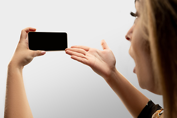 Image showing Close up female hands holding smartphone with blank screen during online watching of popular sport matches and championships all around the world. Copyspace for ad