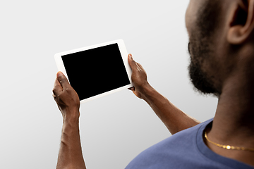 Image showing Close up male hands holding tablet with blank screen during online watching of popular sport matches and championships all around the world. Copyspace for ad