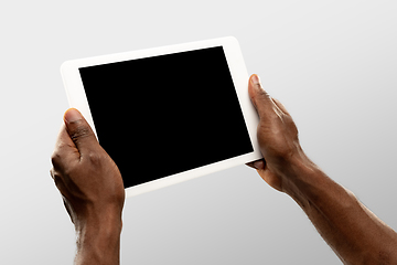 Image showing Close up male hands holding tablet with blank screen during online watching of popular sport matches and championships all around the world. Copyspace for ad