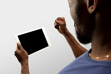 Image showing Close up male hands holding tablet with blank screen during online watching of popular sport matches and championships all around the world. Copyspace for ad