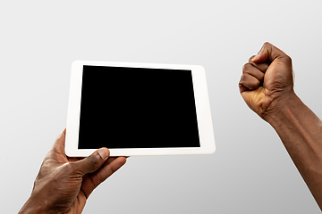 Image showing Close up male hands holding tablet with blank screen during online watching of popular sport matches and championships all around the world. Copyspace for ad