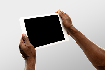 Image showing Close up male hands holding tablet with blank screen during online watching of popular sport matches and championships all around the world. Copyspace for ad