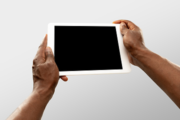 Image showing Close up male hands holding tablet with blank screen during online watching of popular sport matches and championships all around the world. Copyspace for ad