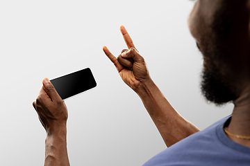 Image showing Close up male hands holding smartphone with blank screen during online watching of popular sport matches and championships all around the world. Copyspace for ad