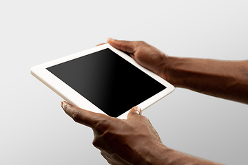 Image showing Close up male hands holding tablet with blank screen during online watching of popular sport matches and championships all around the world. Copyspace for ad