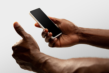 Image showing Close up male hands holding smartphone with blank screen during online watching of popular sport matches and championships all around the world. Copyspace for ad