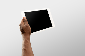 Image showing Close up male hands holding tablet with blank screen during online watching of popular sport matches and championships all around the world. Copyspace for ad