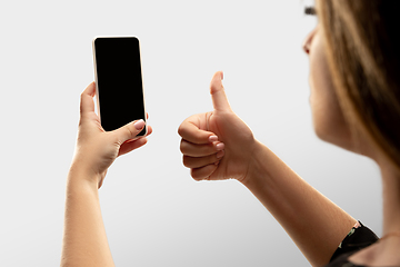 Image showing Close up female hands holding smartphone with blank screen during online watching of popular sport matches and championships all around the world. Copyspace for ad