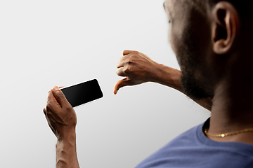 Image showing Close up male hands holding smartphone with blank screen during online watching of popular sport matches and championships all around the world. Copyspace for ad