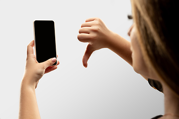 Image showing Close up female hands holding smartphone with blank screen during online watching of popular sport matches and championships all around the world. Copyspace for ad