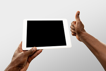 Image showing Close up male hands holding tablet with blank screen during online watching of popular sport matches and championships all around the world. Copyspace for ad