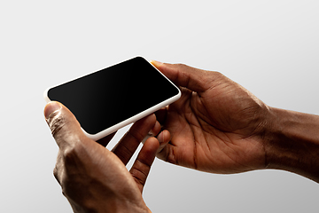 Image showing Close up male hands holding smartphone with blank screen during online watching of popular sport matches and championships all around the world. Copyspace for ad