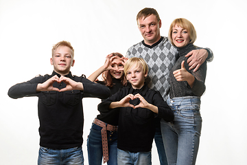 Image showing Portrait of an ordinary large family, teenagers show a gesture in the shape of a heart and joyfully look into the frame