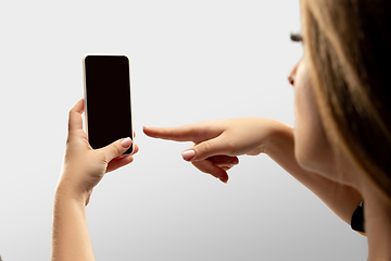 Image showing Close up female hands holding smartphone with blank screen during online watching of popular sport matches and championships all around the world. Copyspace for ad