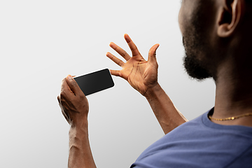 Image showing Close up male hands holding smartphone with blank screen during online watching of popular sport matches and championships all around the world. Copyspace for ad