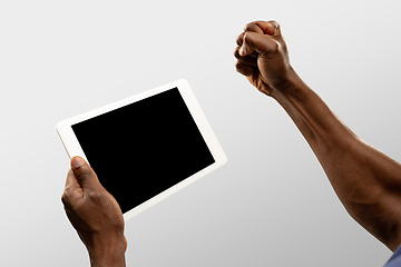 Image showing Close up male hands holding tablet with blank screen during online watching of popular sport matches and championships all around the world. Copyspace for ad