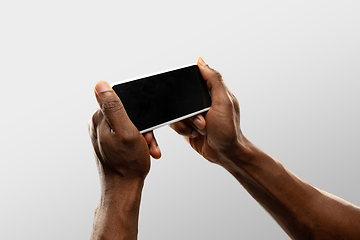 Image showing Close up male hands holding smartphone with blank screen during online watching of popular sport matches and championships all around the world. Copyspace for ad