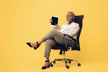 Image showing Young african-american woman in casual wear on yellow background. Bodypositive female character, plus size businesswoman