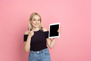 Image showing Portrait of young caucasian woman with bright emotions on coral pink studio background