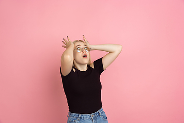 Image showing Portrait of young caucasian woman with bright emotions on coral pink studio background