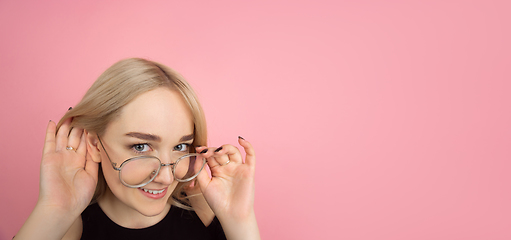 Image showing Portrait of young caucasian woman with bright emotions on coral pink studio background