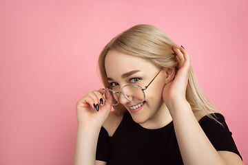 Image showing Portrait of young caucasian woman with bright emotions on coral pink studio background