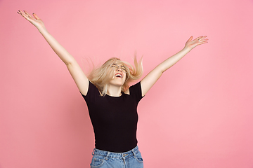 Image showing Portrait of young caucasian woman with bright emotions on coral pink studio background