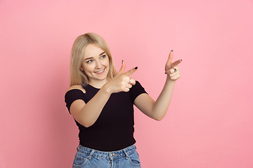 Image showing Portrait of young caucasian woman with bright emotions on coral pink studio background