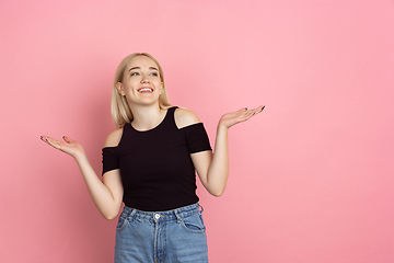 Image showing Portrait of young caucasian woman with bright emotions on coral pink studio background