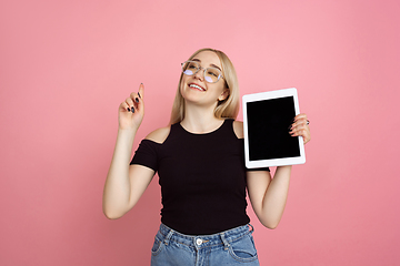 Image showing Portrait of young caucasian woman with bright emotions on coral pink studio background