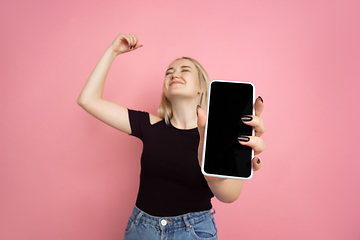 Image showing Portrait of young caucasian woman with bright emotions on coral pink studio background