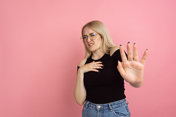 Image showing Portrait of young caucasian woman with bright emotions on coral pink studio background