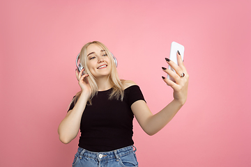 Image showing Portrait of young caucasian woman with bright emotions on coral pink studio background