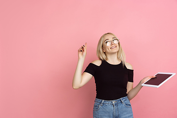 Image showing Portrait of young caucasian woman with bright emotions on coral pink studio background