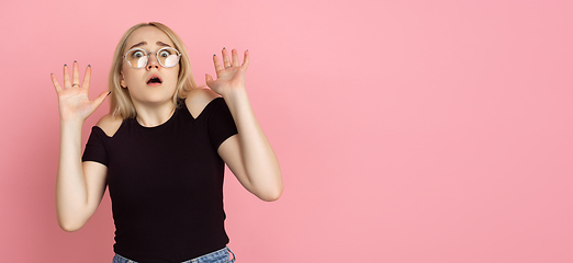 Image showing Portrait of young caucasian woman with bright emotions on coral pink studio background