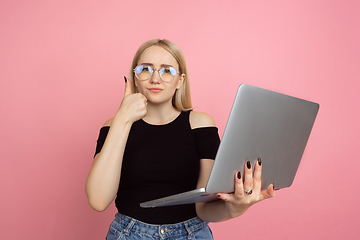 Image showing Portrait of young caucasian woman with bright emotions on coral pink studio background