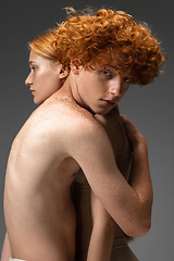 Image showing Portrait of beautiful redhead couple isolated on grey studio background. Concept of beauty, skin care, fashion and style
