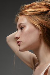 Image showing Portrait of beautiful redhead woman isolated on grey studio background. Concept of beauty, skin care, fashion and style