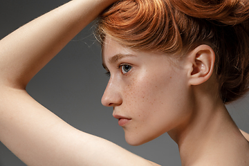 Image showing Portrait of beautiful redhead woman isolated on grey studio background. Concept of beauty, skin care, fashion and style