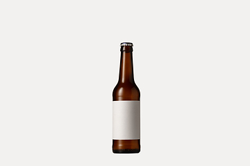 Image showing Empty golden colored beer bottle. Isolated on white studio background