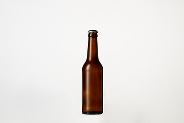 Image showing Empty golden colored beer bottle. Isolated on white studio background