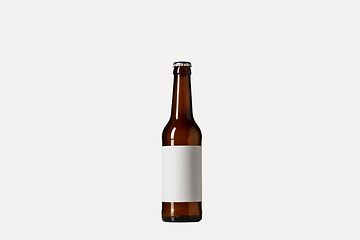 Image showing Empty golden colored beer bottle. Isolated on white studio background